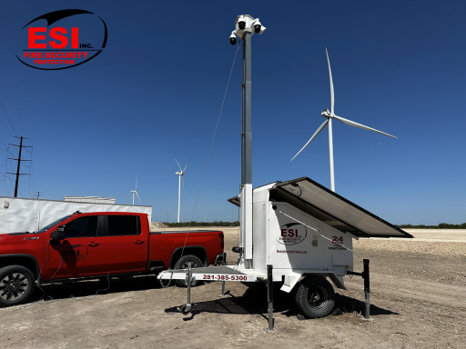 Mobile surveillance trailer equipped with cameras and solar panels in a remote location, showcasing smart monitoring solutions for off-grid security.