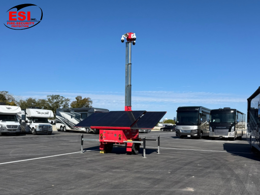 Mobile security trailer vs fixed cameras comparison showing solar-powered trailer deployed in large commercial parking lot